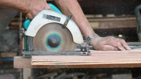 Carpenter using circular saw cutting wooden board in carpentry workshop Stock Footage 155983080