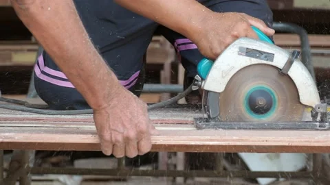 Carpenter using circular saw cutting wooden board in carpentry workshop Stock Footage 155983082