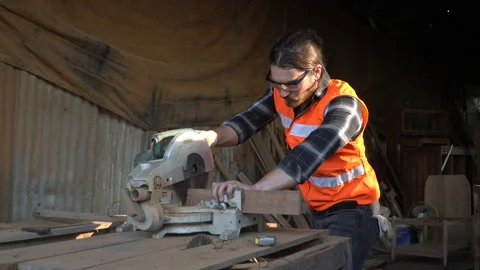 Carpenter using circular saw cutting wooden plank in workshop . Young man bui Stock Footage 158425093