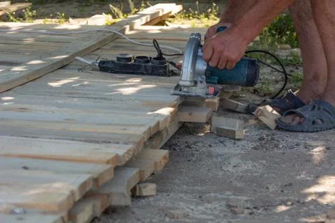 Carpenter using circular saw for cutting wooden boards. Construction details  Foto stock