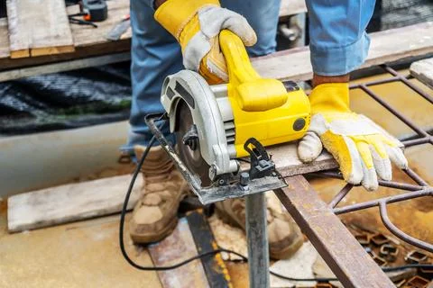 Carpenter using circular saw for cutting wooden boards with power tools, co.. Foto stock