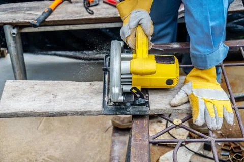 Carpenter using circular saw for cutting wooden boards with power tools, co.. Foto stock
