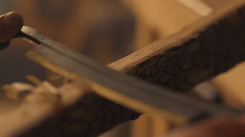 Carpenter using draw knife to peel bark off wood in workshop Stock Footage 275631096