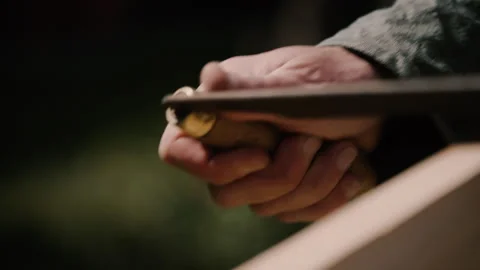 Carpenter using drawknife on plank of wood, hand tools close up in sunlight Stock Footage 271190455