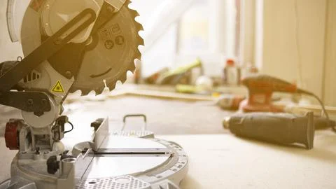 Carpenter using electric circular saw to cut a wooden board. Stock Photos