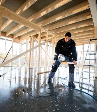 Carpenter Using Electric Hand Saw To Cut Wood At Site 写真素材