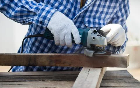 Carpenter using grinder on wood Stock Photos