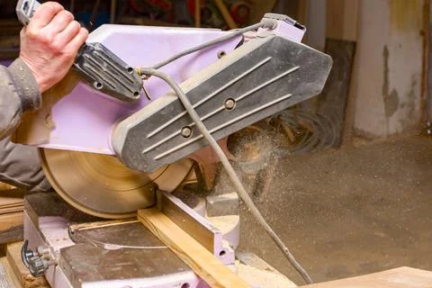 Carpenter is using hand held circular saw to cut boards, making clean precise Stock Photos