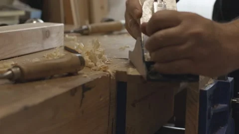 Carpenter using a hand plane on his workbench Vídeos de archivo 153109674