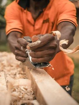 Carpenter using a hand plane to smooth wooden surface. Stock-Fotos