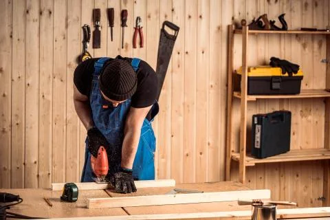 A carpenter using a jigsaw to cut wood cuts bars Stock Photos