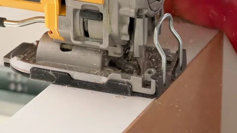 Carpenter using jigsaw cutting a piece of wood composite board power tool Stock Footage 325057822