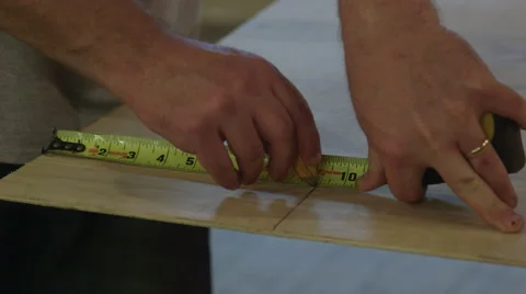 Carpenter Using Measuring Tape to Mark Section of Plywood Vídeo Stock 61503658