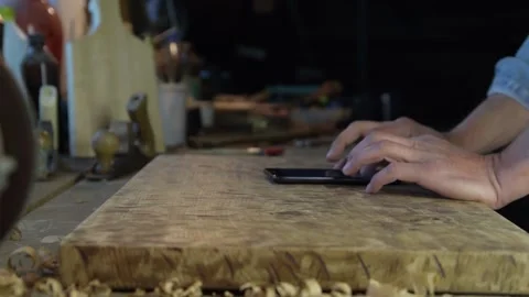 A carpenter using a mobile phone in his workshop Video stock 131966492