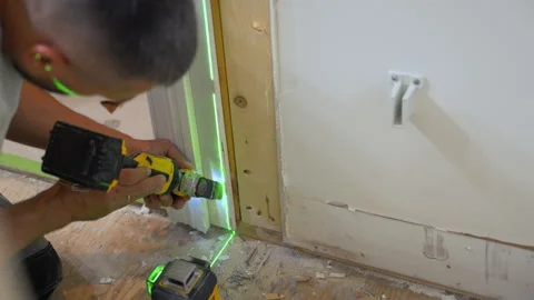 Carpenter using an oscillating power tool to cut drywall and wood around a Stock Footage 346801918