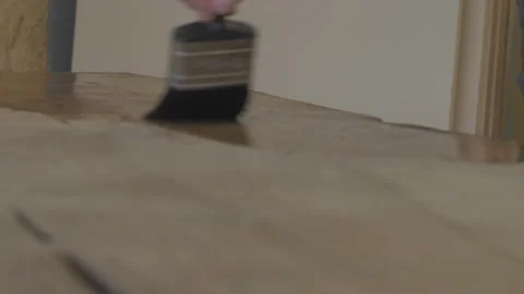 Carpenter using paint brush to varnish wood Stock Footage 139449218