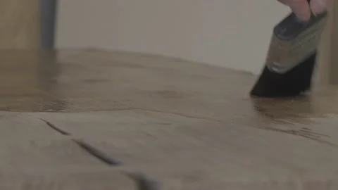Carpenter using paint brush to varnish wood Stock Footage 139449221