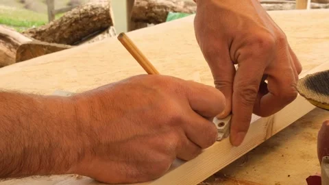 Carpenter using pencil and steel square to mark wooden workpiece for furniture p Stock Footage 332875338