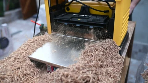 Carpenter using a planing machine on a wooden plank Stock Footage 243123329