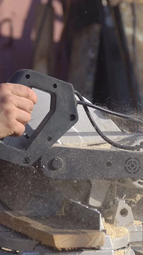 Carpenter using a powerful electric miter saw for precision wood cutting Stock Footage 341678616