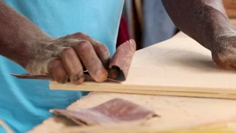 Carpenter using sandpaper to smoothen surface of a wood for furniture works Stock Footage 223791649