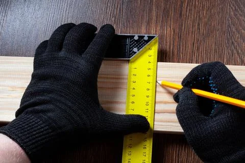 Carpenter using Square ruler and pencil for measuring on wooden board Stock Photos