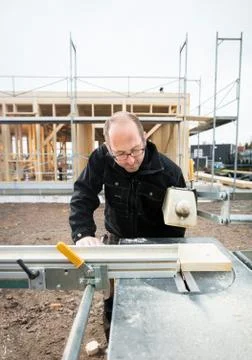 Carpenter Using Table Saw To Cut Wood At Site 写真素材