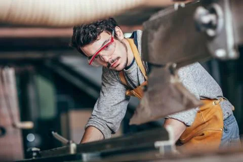 Carpenter using table saw at workshop Stock Photos