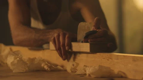 Carpenter using wood planer on plank Stock Footage 275629237