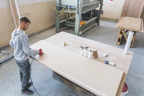 Carpenter using working tools while working on a wood in carpentry workshop Stock Photos