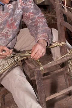 Carpenter weaves straw Stock Photos