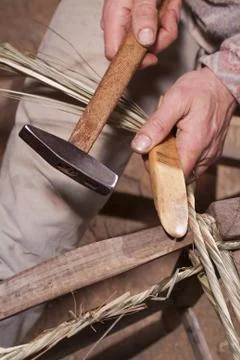 Carpenter weaves straw Stock Photos