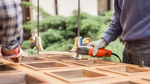 Carpenter at work with angular Sander. Stock Photos