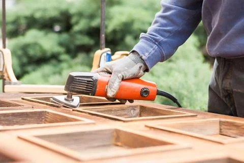 Carpenter at work with angular Sander. Stock Photos