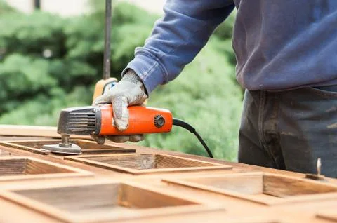 Carpenter at work with angular Sander. Stock Photos