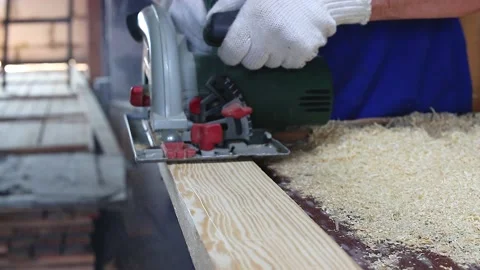 Carpenter in work clothes and gloves neatly cuts piece Stock Footage 159150627