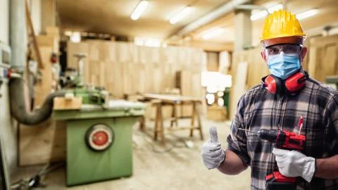 Carpenter at work protects the face with the surgical mask. Carpentry. Covid- Stock-Fotos
