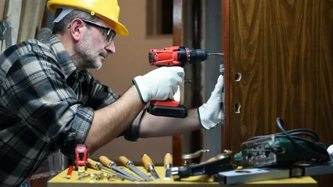 Carpenter at work repairs and installs the door lock. Carpentry. Stock Footage 143156217