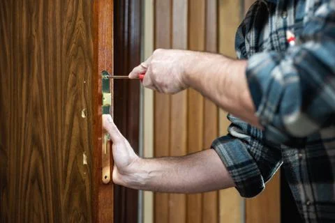 Carpenter at work repairs the door lock. Carpentry. Stock-Fotos