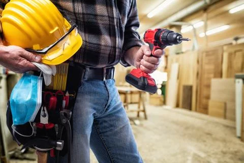 Carpenter with work tools and surgical mask on white background. Carpentry. C Stock Photos