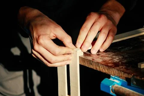 Carpenter at workbench nails down small wooden box.Hands of worker with old axe Stock Photos