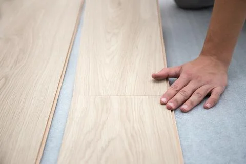 Carpenter worker installing laminate flooring in the room Stockfoto's