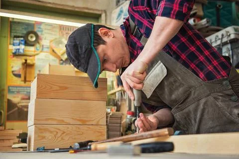 Carpenter working with a chisel Carpenter working with a chisel and hammer... Stock Photos