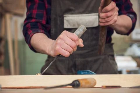 Carpenter working with a chisel Carpenter working with a chisel and hammer... Stock Photos