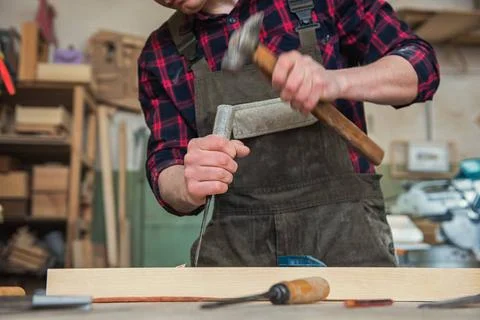 Carpenter working with a chisel Carpenter working with a chisel and hammer... Stock Photos