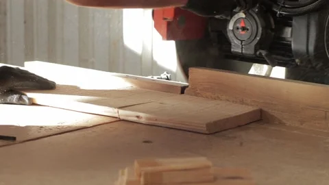 Carpenter working on a circular saw cutting a wooden plank in a workshop Video stock 173935932
