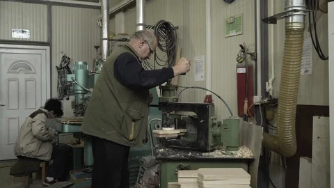 Carpenter working on copy shaper machine, woman drilling boards in background. Stock Footage 88162535