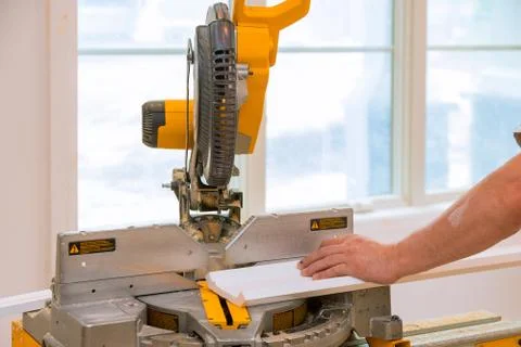 Carpenter working cutting molding by circular saw. Stock Photos
