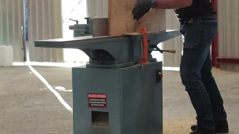 Carpenter working on an Electric Benchtop Jointer cutting wooden board Video stock 173930049