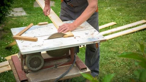 Carpenter working with electric buzz saw cutting wooden boards Foto stock